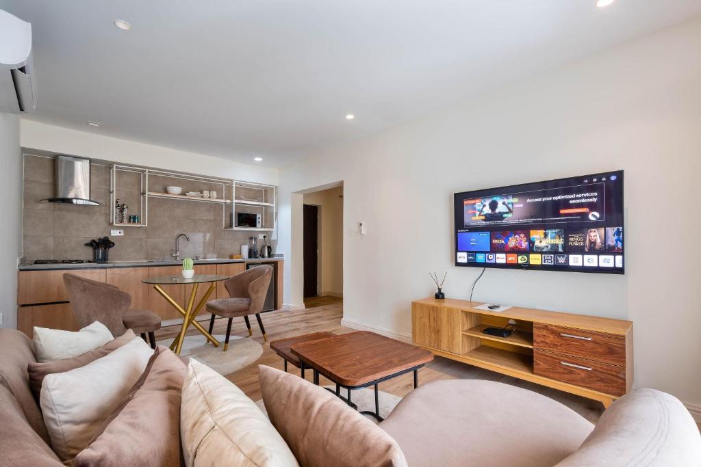 a living room with a couch and a tv at Aima Apartments in Lekki