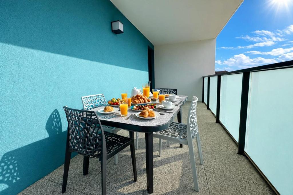 a table with food and orange juice on a balcony at The Ill in Softness calm & elegant in Illkirch-Graffenstaden