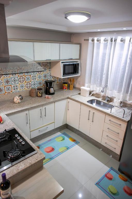 a kitchen with white cabinets and a stove top oven at B&B Apartamento Completo e Decorado com 3 Quartos in São José dos Pinhais