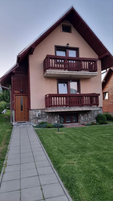 a large house with a balcony and a sidewalk at Chalúpka Paci in Ždiar