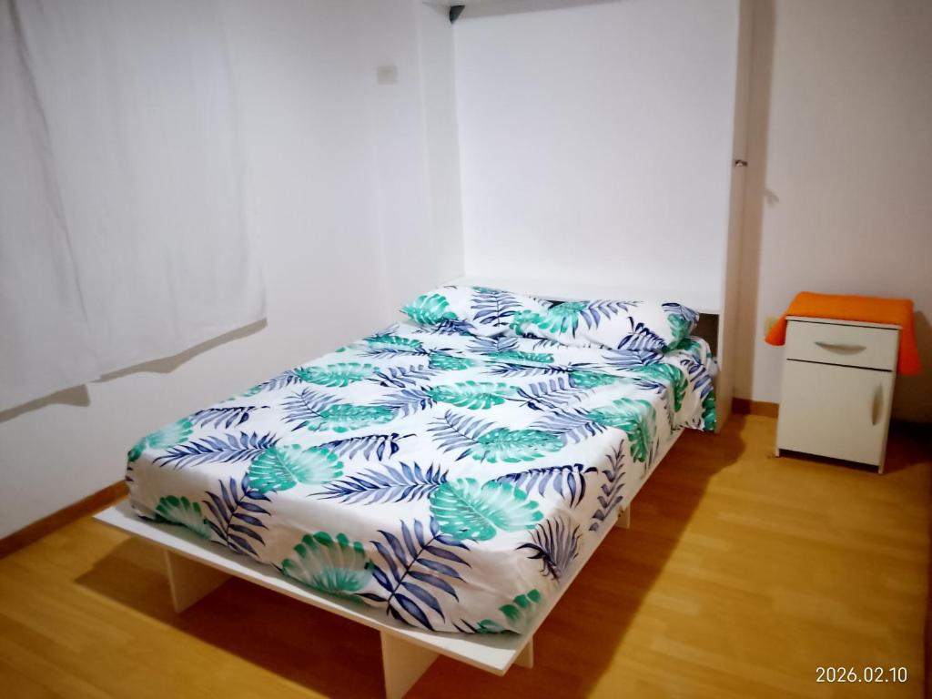 a bedroom with a bed with a white and green blanket at Tu hogar en Concordia in Concordia