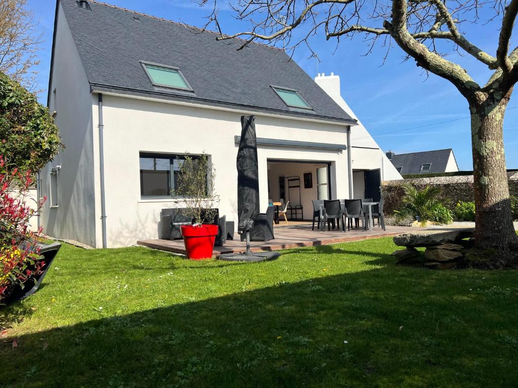 a white house with a patio and a yard at MAISON NEUVE LUMINEUSE AU CALME PROCHE DES PLAGEs in Quiberon