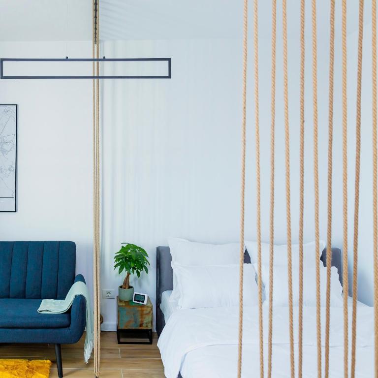 a bedroom with a swinging bed and a blue chair at Vibrant Studio in Timişoara