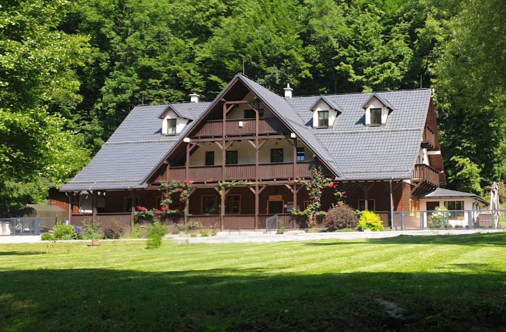 a large wooden house with a gambrel roof at Hrochoťský mlyn in Hrochoť