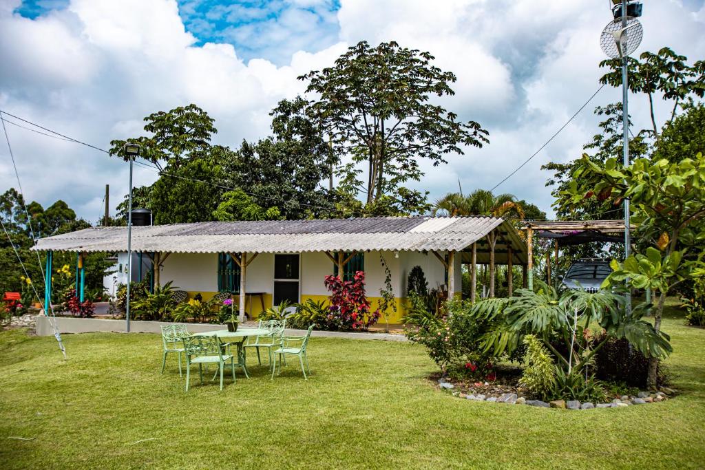 a house with a table and chairs in the yard at Finca La Molienda, espléndido Mirador del Quindio in Circasia