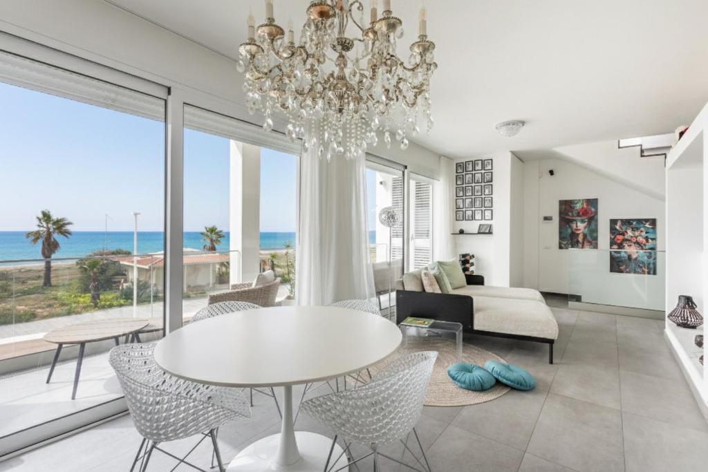 a living room with a chandelier and a table and chairs at Luxury beach front in Torre Grande