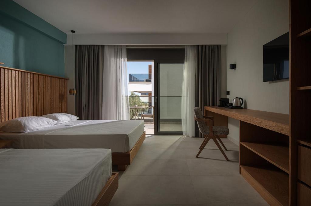 a hotel room with two beds and a balcony at HP Family Suites in Neos Marmaras