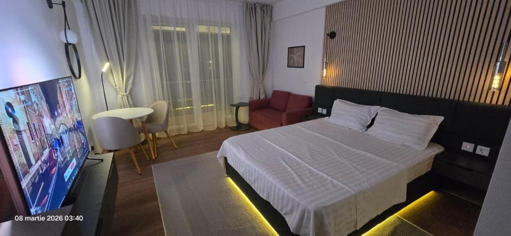 a hotel room with a bed and a flat screen tv at Sunset Beach Studio by Blaxy Resort Olimp in Olimp