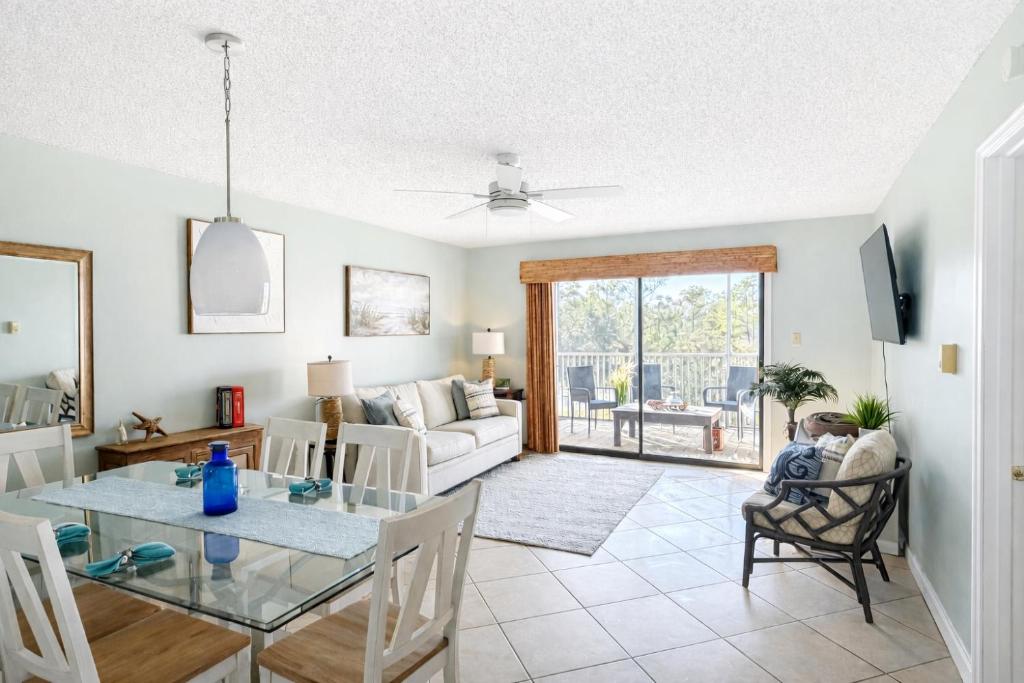 a living room with a table and a couch at Latitude 107 2 bedroom walk to beach in Orange Beach