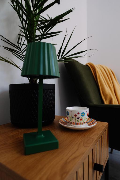 a green lamp sitting on top of a table with a cup at 4 Pory Roku in Darłowo