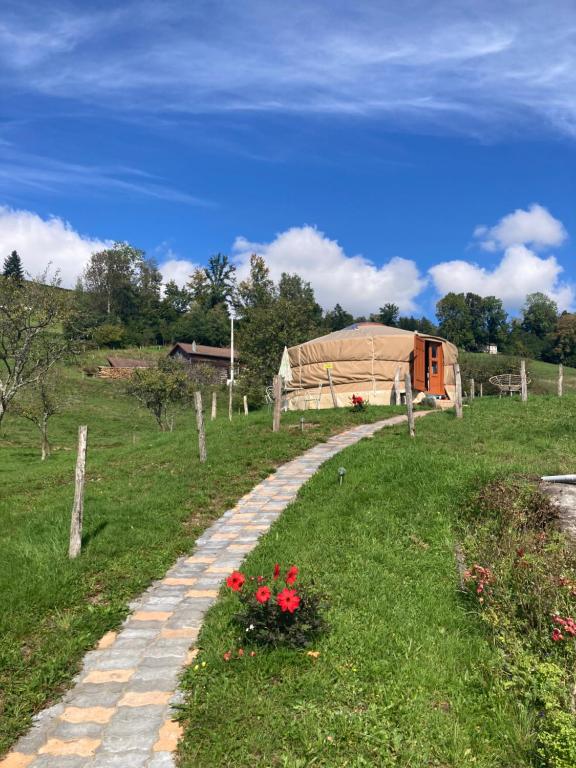 a stone path leading to a tent in a field at Yourte à la ferme in Ramonchamp