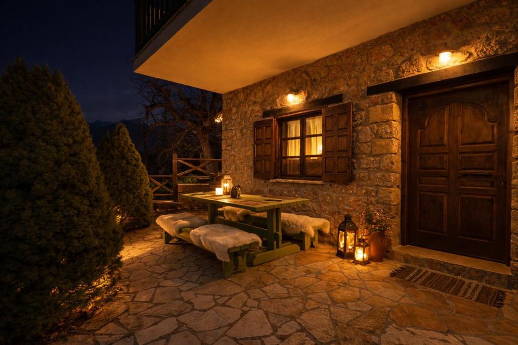a stone house with a table and benches on a patio at Petrino Lodge Stone Mountain Retreat in Kato Trikala Korinthias