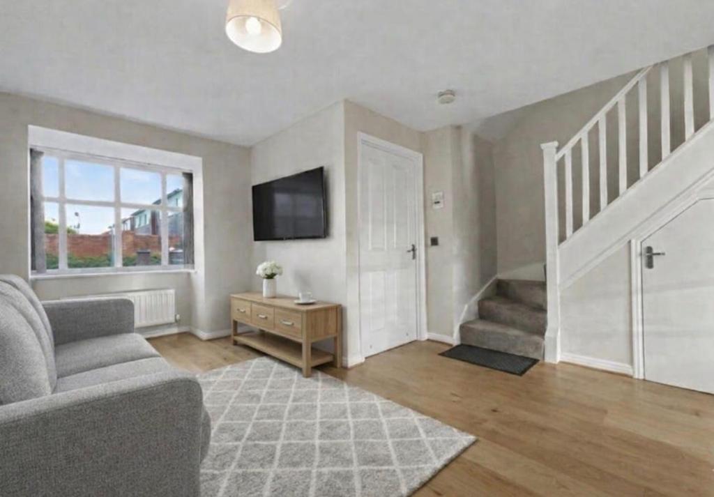 a living room with a couch and a tv at Golf Let in Southport