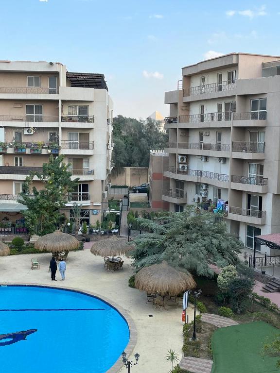 a view of a resort with a pool and some buildings at Pyramid View Apartment near GEM in Ghaţāţī