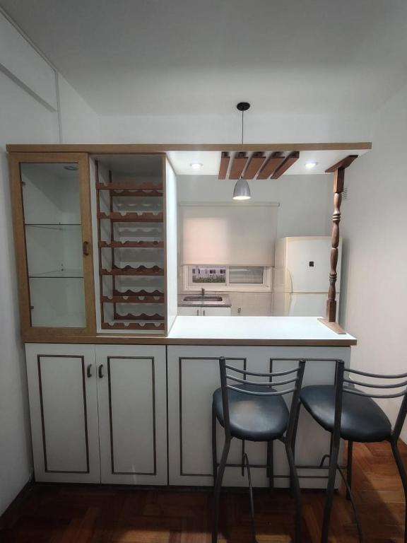 a kitchen with two chairs and a counter with a counter top at Departamento Zarate Centro in Zárate