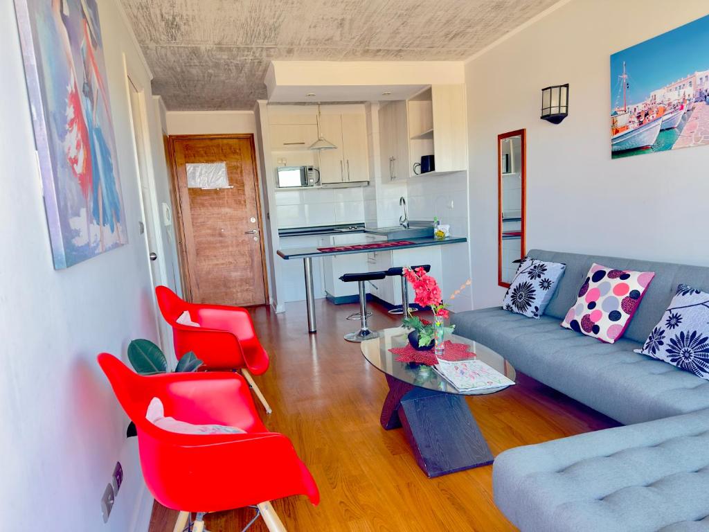 a living room with a couch and red chairs at Apartamento Vista Buena in Talca