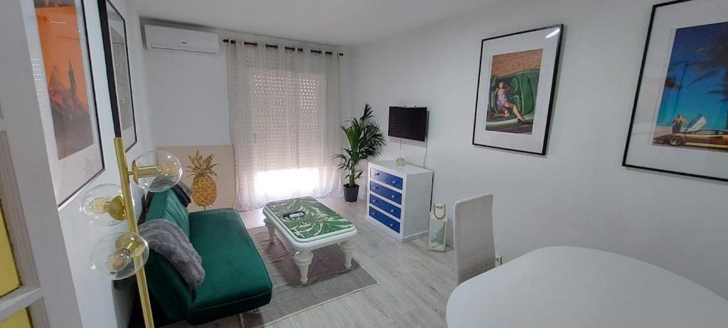 a small room with a green couch and a bed at Apartamento Marandel in Ronda