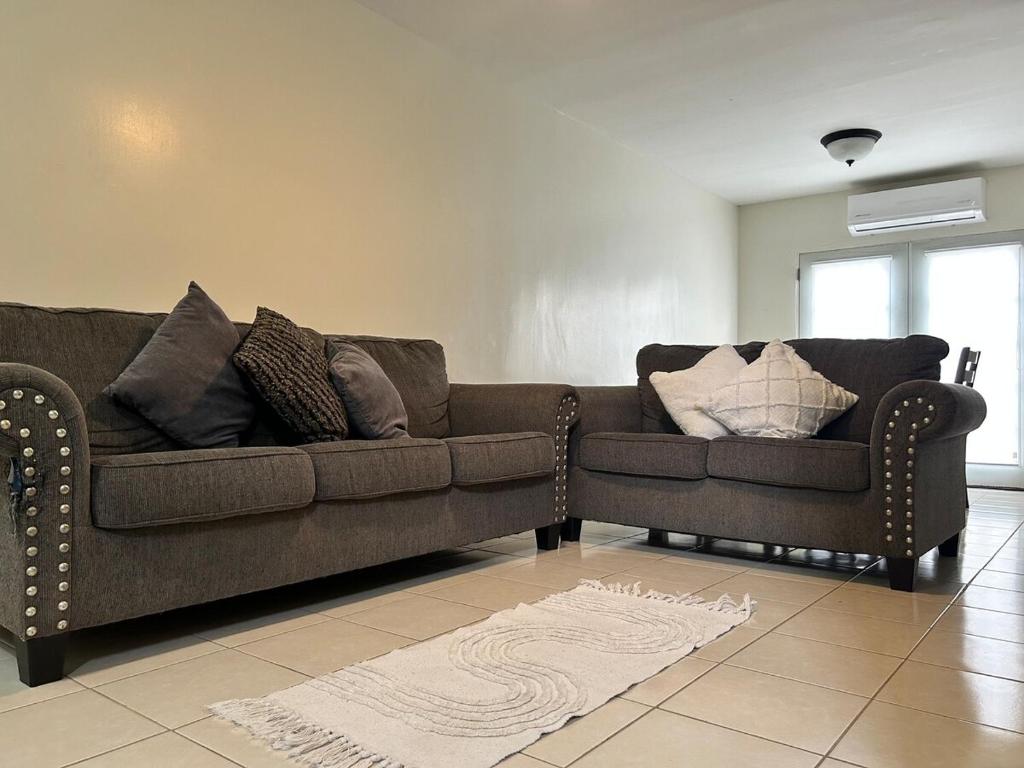 a living room with a brown couch with pillows at Casa Antonio in Reynosa