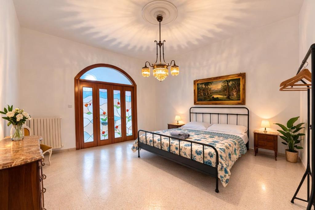 a bedroom with a bed and a chandelier at ADAapartmenthousesalerno in Salerno