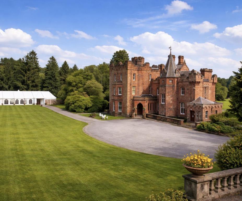an old castle with a grassy yard in front of it at Friars Carse Country House Hotel in Dumfries