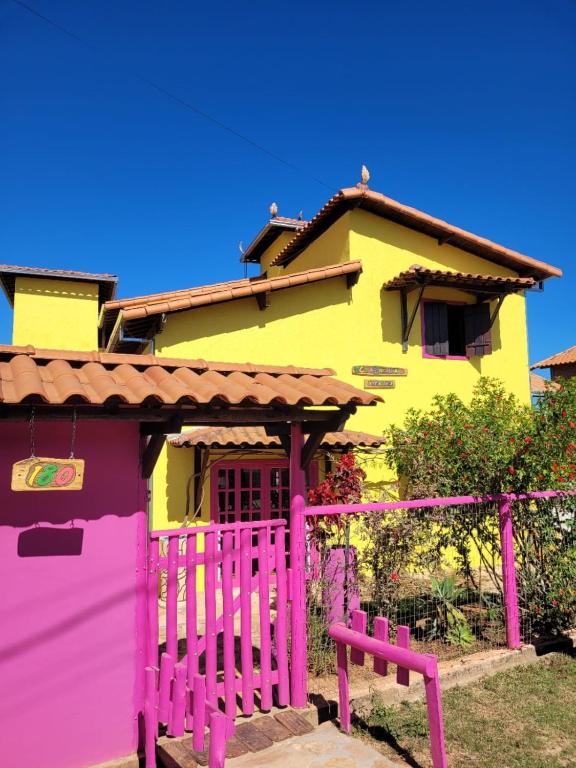 a colorful house with a pink fence in front of it at Casa Encantada in Sêrro