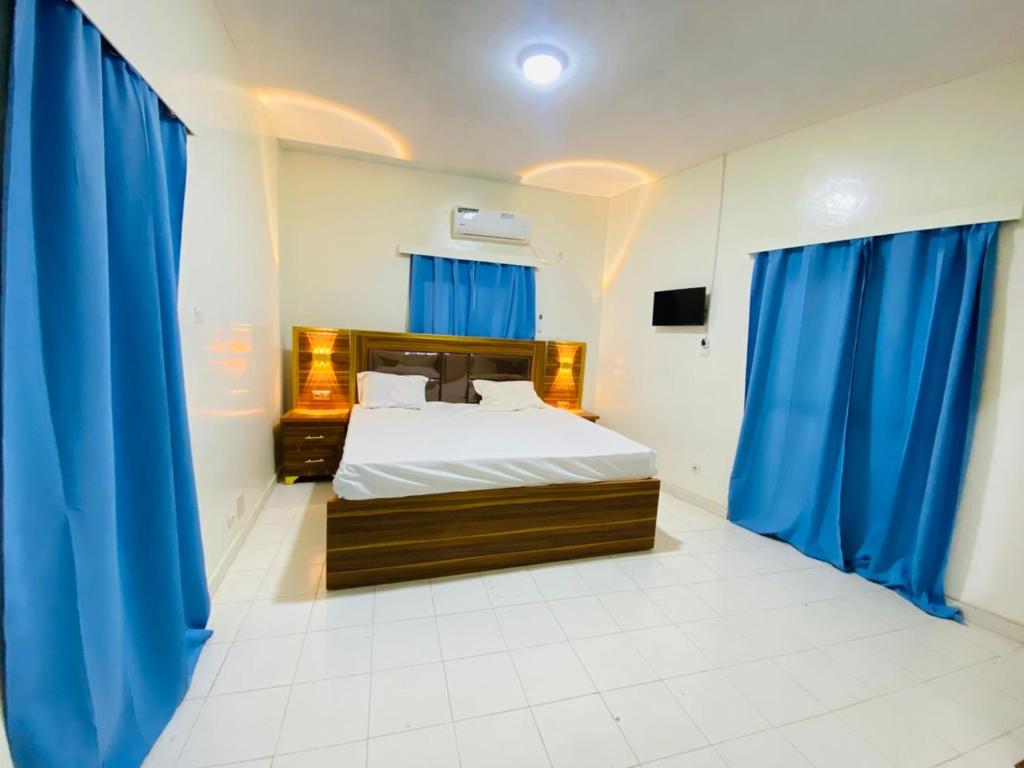 a bedroom with a bed with blue drapes at Sanga City in Bakel