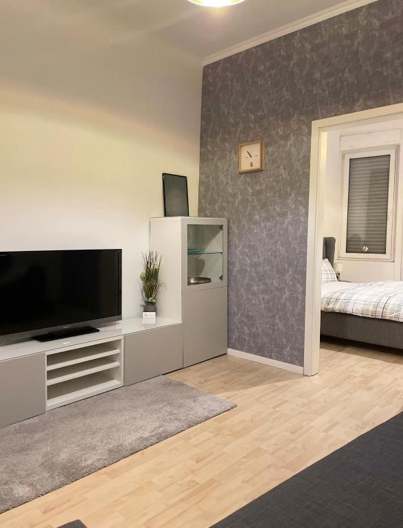 a living room with a flat screen tv on a entertainment center at Wohnung Karl-Marx 1 in Trier