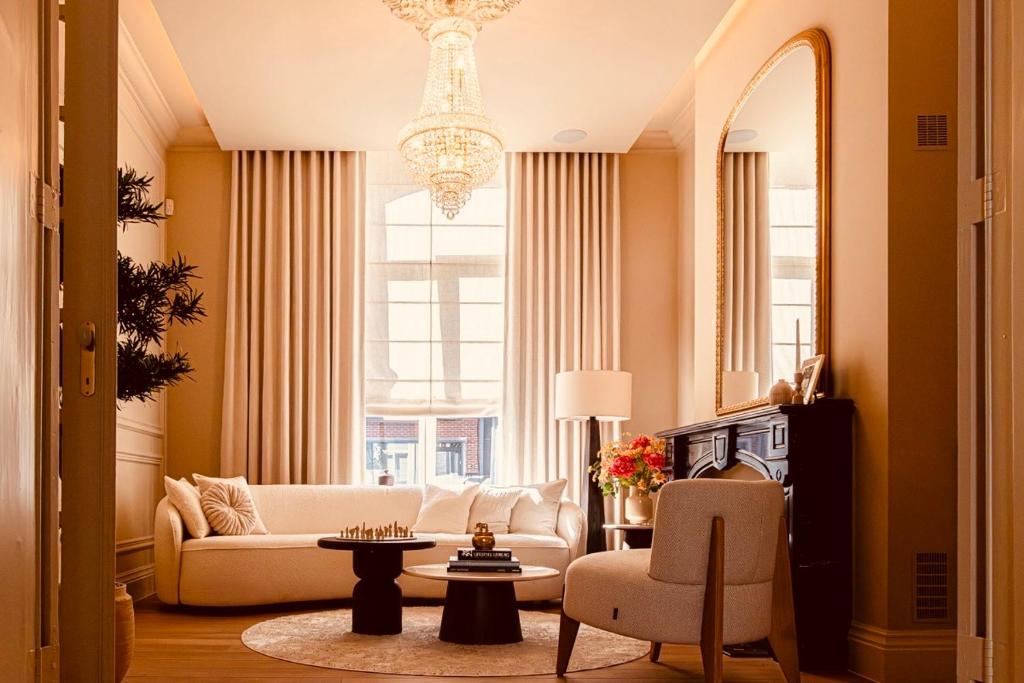 a living room with a white couch and a chandelier at DEUXHOMMES Boutique B&B Massage&Spa in Hasselt