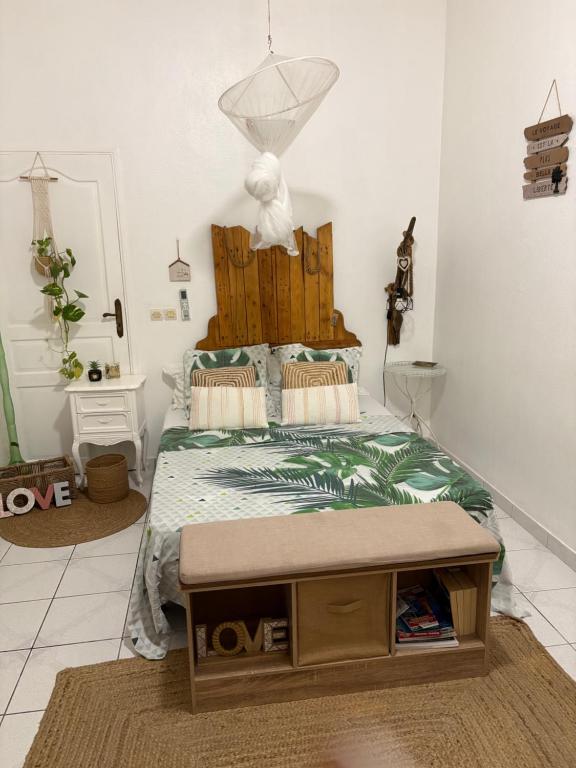 a bedroom with a bed with a wooden headboard at Le Biabiany in Bouillante