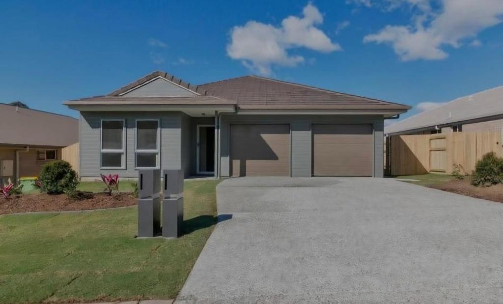 a house with a driveway in front of it at One Bedroom One Bathroom Unit With a New TV in Wulkuraka
