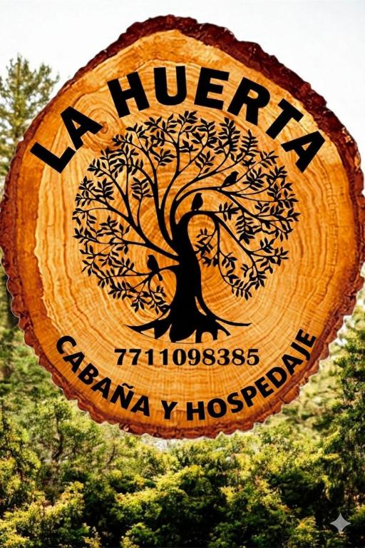 a wooden sign for aury pharmacy hospital with a tree on it at LA HUERTA Cabaña y Hospedaje in Huasca de Ocampo