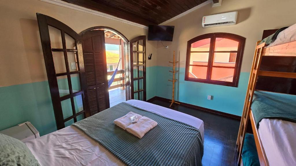 a bedroom with a bed with a towel on it at Almar Hospedagem 2 ARRAIAL DO CABO in Arraial do Cabo