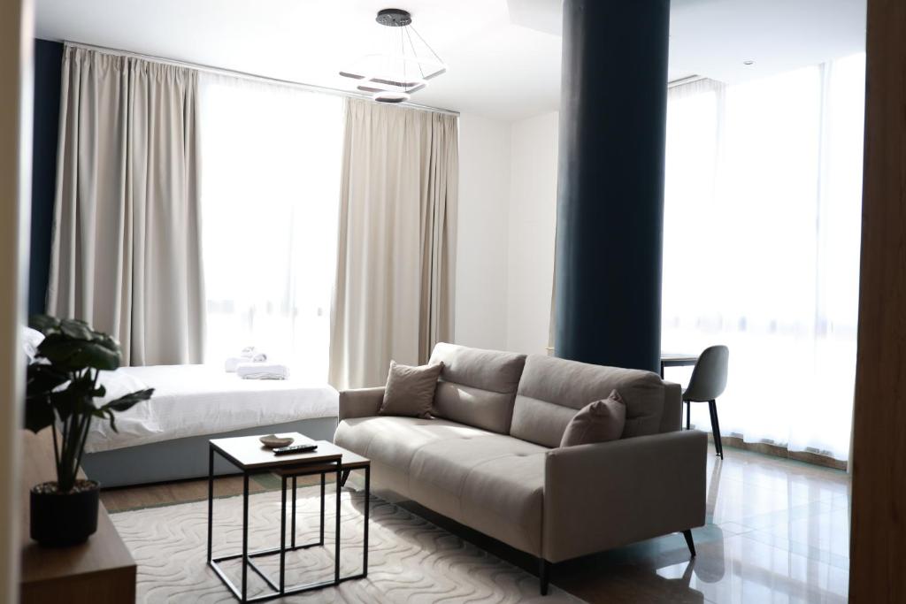 a living room with a couch and a bed at Palm Vista Retreat in Durrës