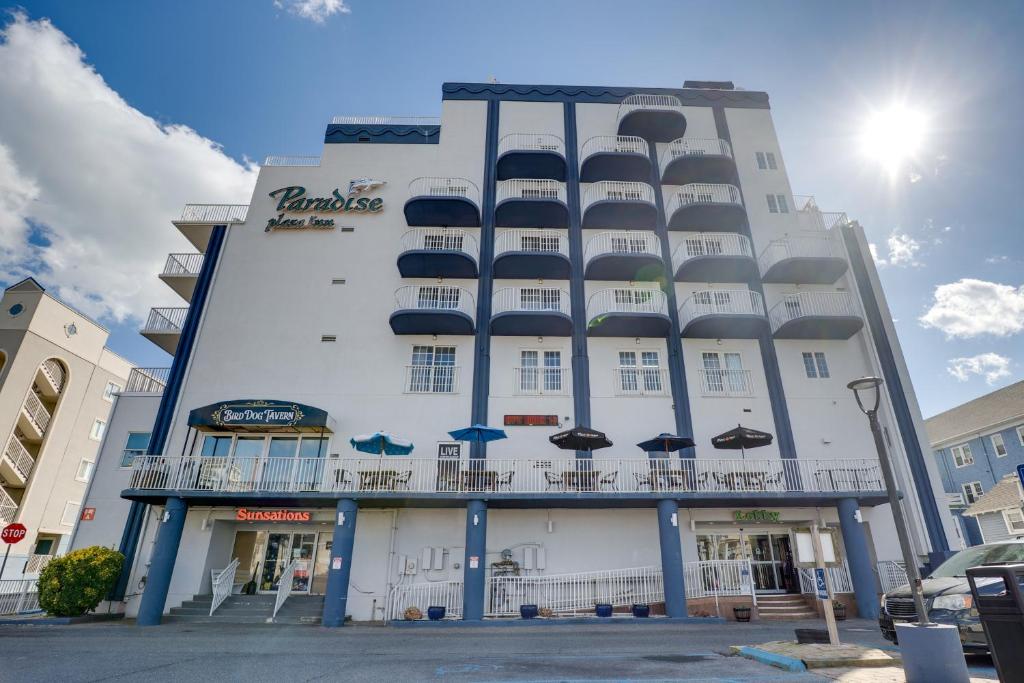 a large white building with umbrellas in front of it at Paradise Plaza Inn in Ocean City