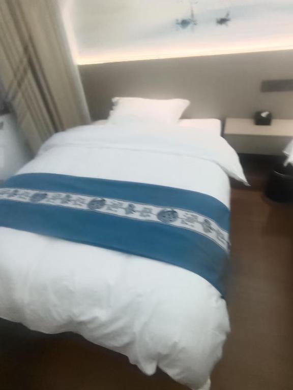 two beds in a hotel room with white pillows at 太溪民宿 in Zhangjiajie Hehua Airport