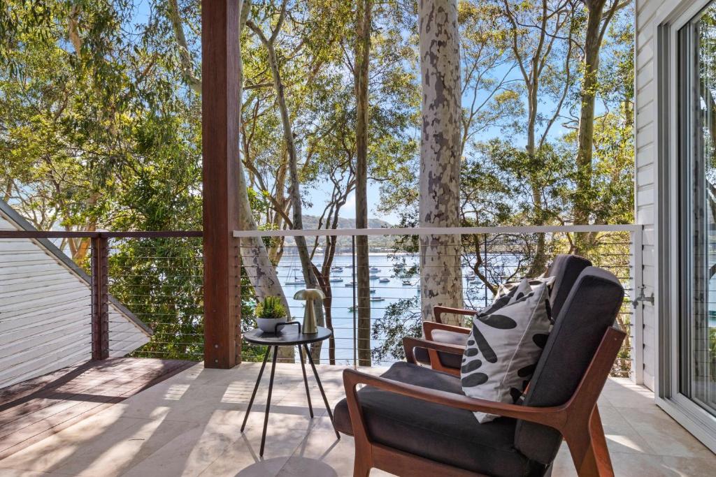 a porch with a chair and a view of the water at The Treehouse Avalon in Whale Beach