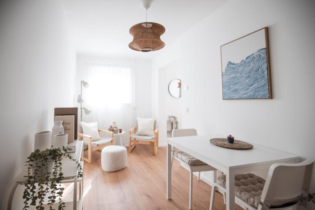 a white living room with a white table and chairs at Penthouse & Forest Retreat - near city in Bornheim