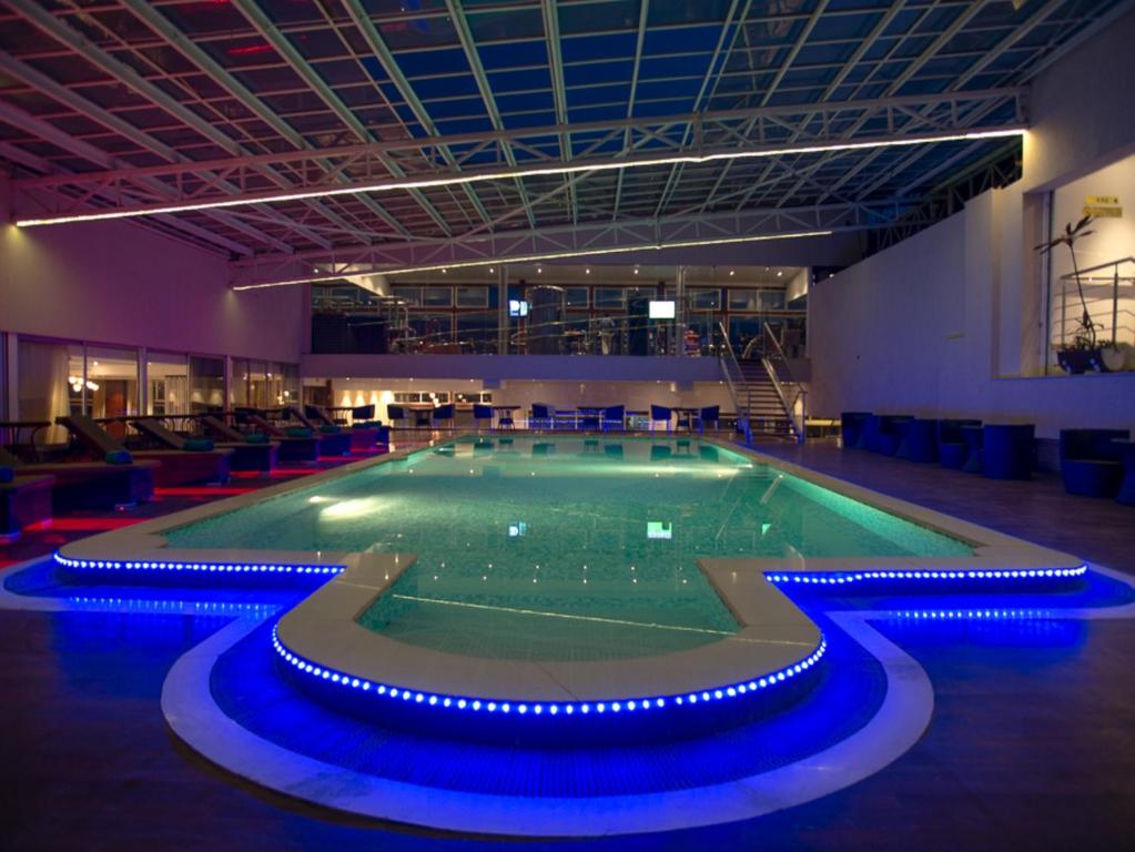 una gran piscina con luces azules alrededor. en Cloud Hotel & Suites, en Nairobi