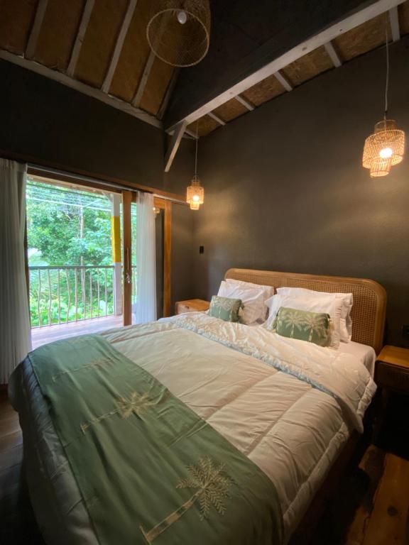 a bedroom with a large bed with a window at Seenau House Bali in Selemadeg