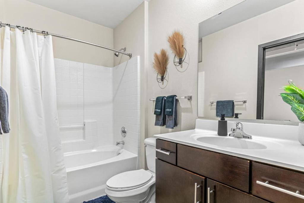 a bathroom with a sink and a toilet and a tub at 2KBD2BA Steps from Target Center+GYM+KTCHN+LNDRY in Minneapolis