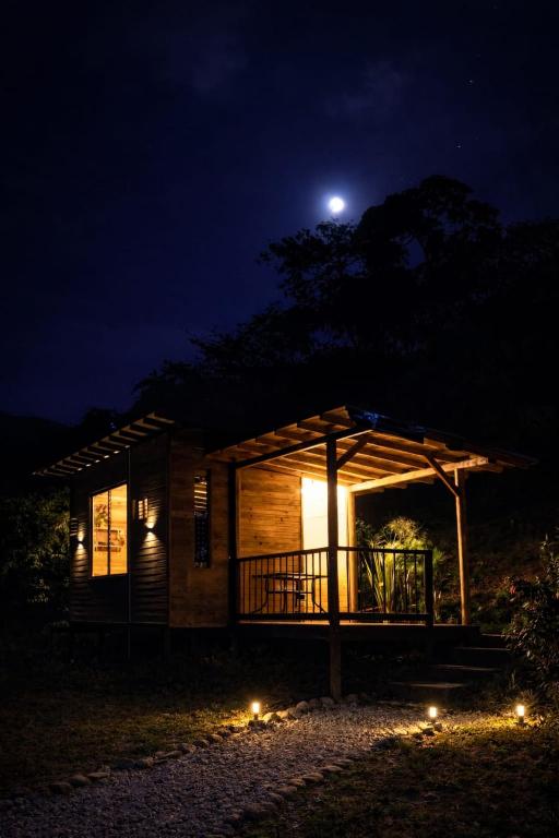 a cabin at night with the moon in the sky at Refugio La Tángara del Río in Cocorná
