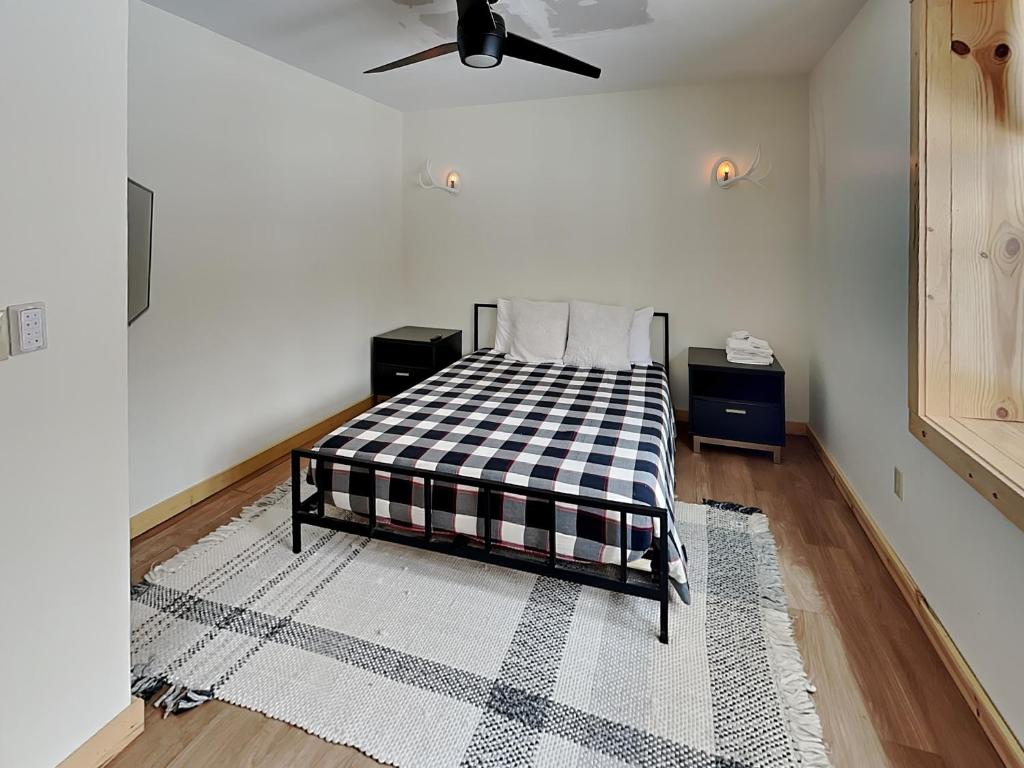 a bedroom with a bed with a black and white checkered blanket at Camp Wondermore in Swanton