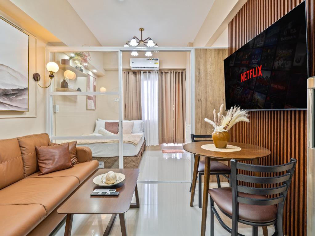 a living room with a couch and a table at Mactan Cebu Cozy Relaxing Studio with Pool View Balcony in Pajak