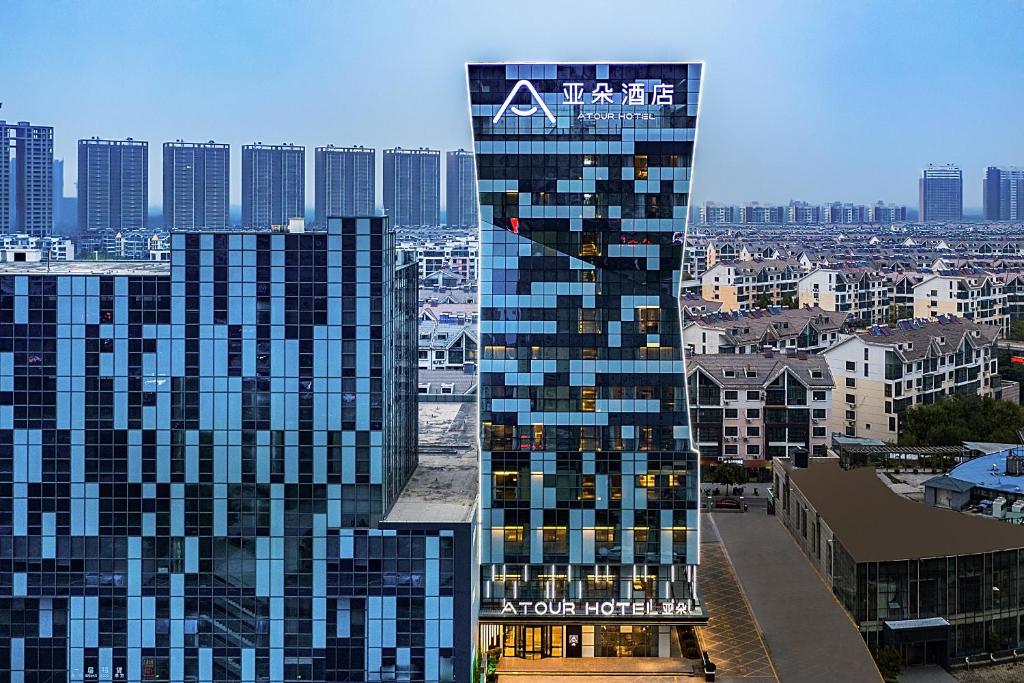 a tall building with a sign on the side of it at Atour Hotel Jining High-tech Zone in Jining
