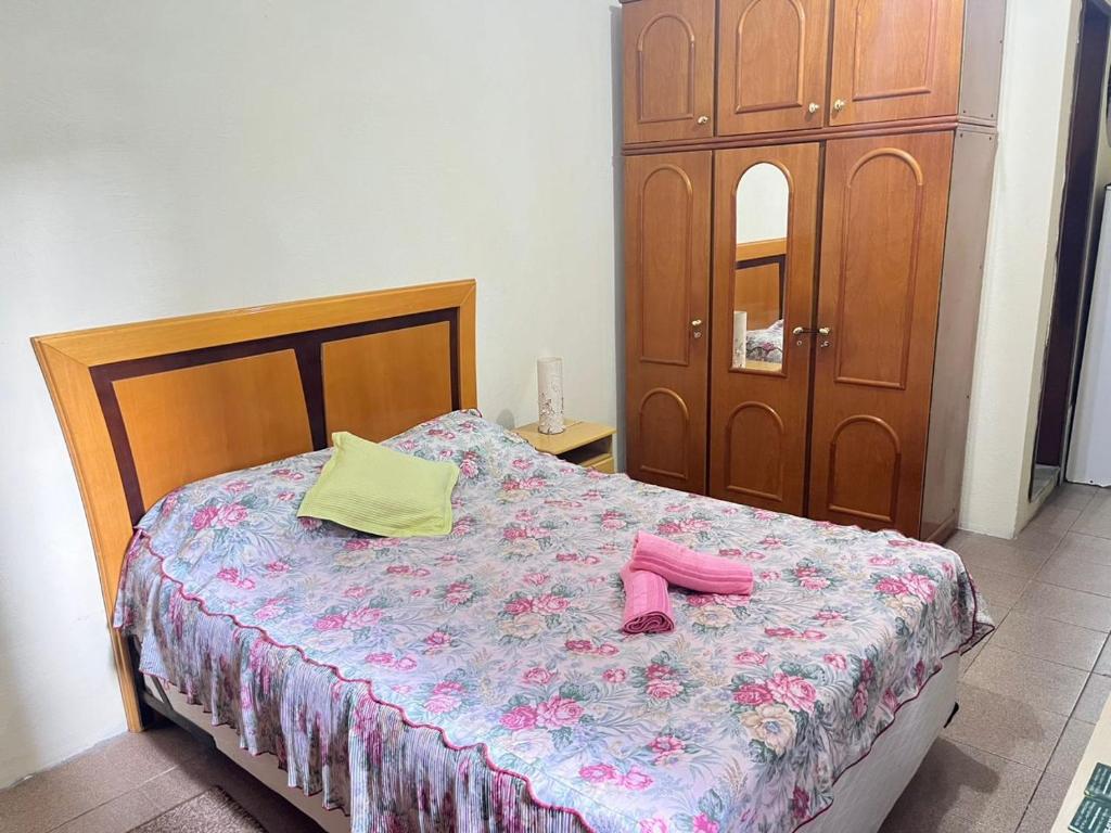a bedroom with a bed with pink shoes on it at Loft para casal em prédio familiar 3,5km do centro histórico in Petrópolis