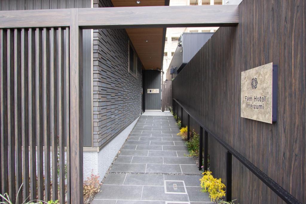 a walkway leading to a building with a sign on it at Fam Hotel Imaizumi in Fukuoka