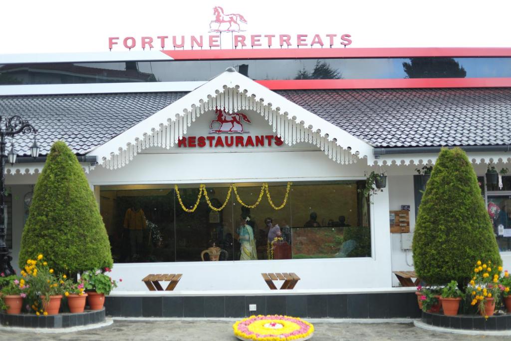 a restaurant with a sign on the front of it at Fortune Retreats in Ooty