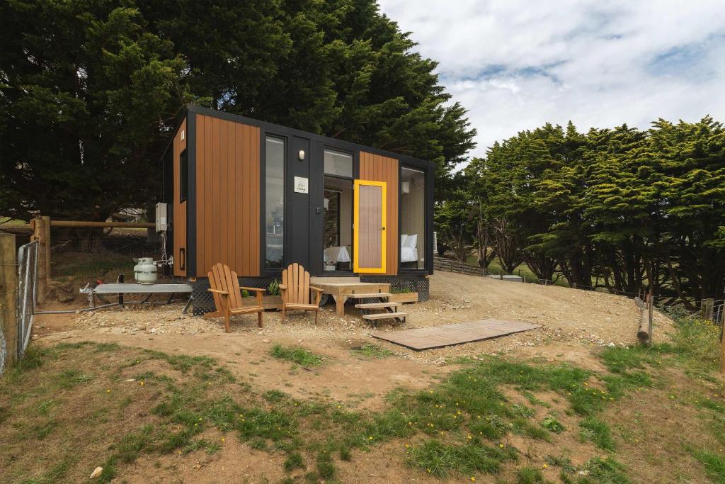 a tiny house with two chairs and a table at Sunset Hill by Tiny Away in Dollar