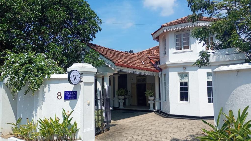 a white house with a clock on a gate at W Hotel Mount Lavinia - Colombo in Colombo
