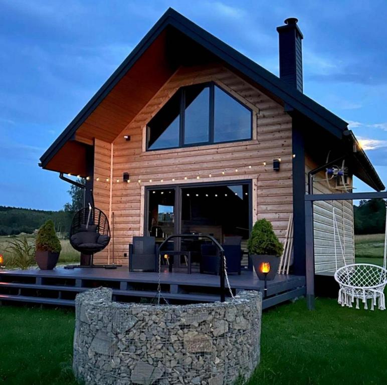 a log cabin with a porch and a patio at Jaworowe Wzgórze in Wysowa-Zdrój